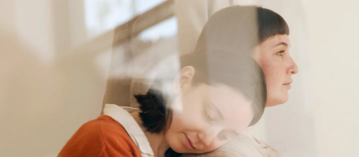 a woman's profile overlayed with other silhoeuttes and the glare from a window