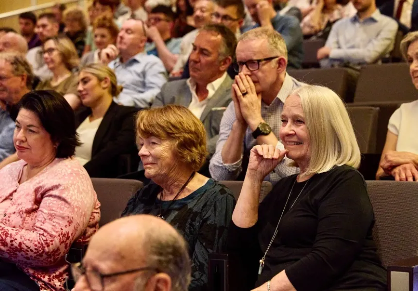 Audience members sit in the crowd, Collette Breen and Pat O'Reilly visible