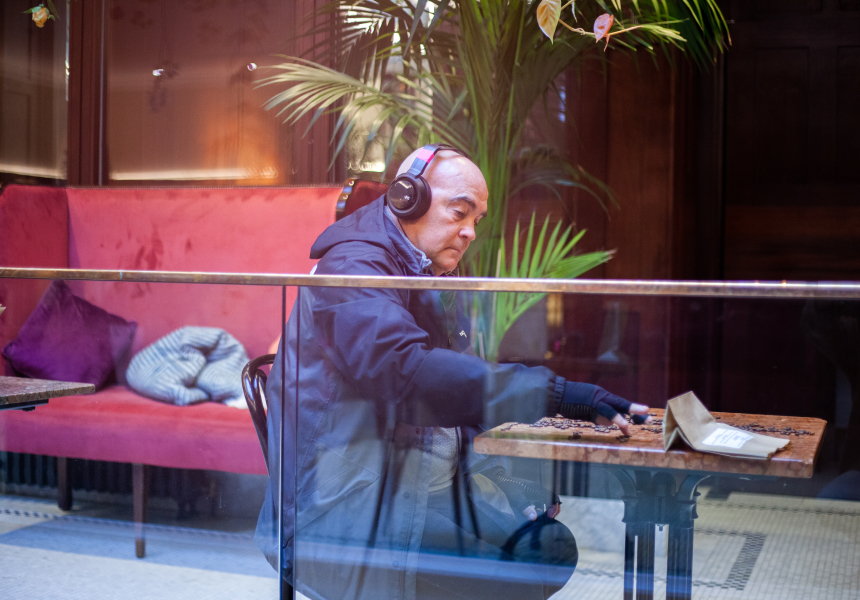 A man sitting in a coffee shop with headphones on