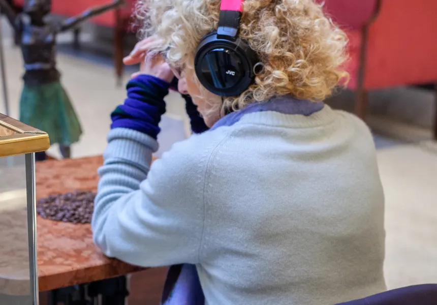 A woman sitting in a coffee shop with headphones on