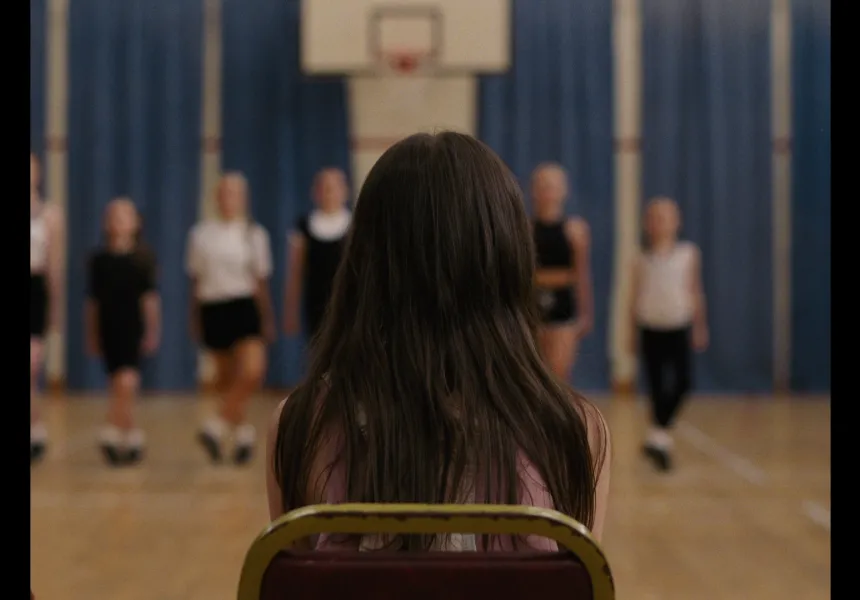 CLODAGH image, little girl facing a way from camera sitting in dance class