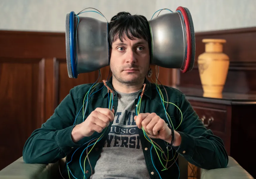 EARMARK image, man with large silver device over his ears