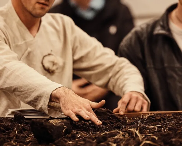 Distillation prod image-Lukes hands in soil