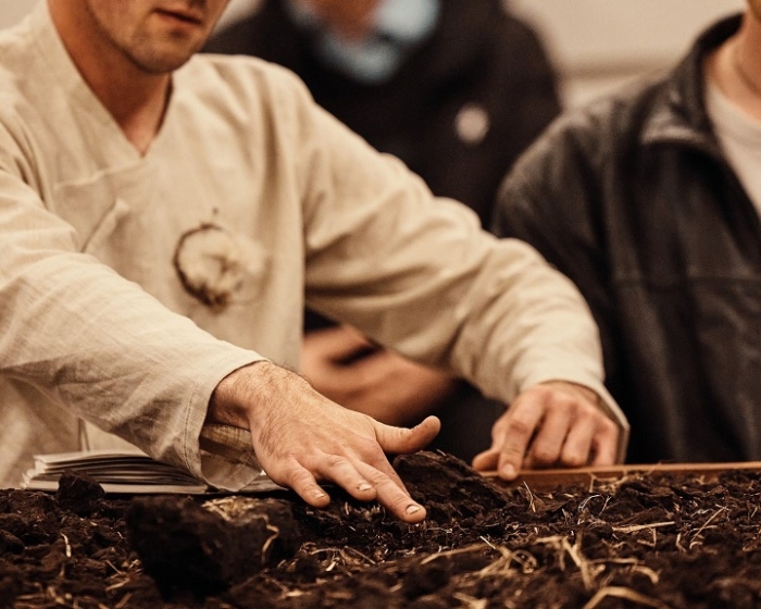 Distillation prod image-Lukes hands in soil