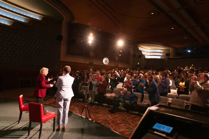 Mary Robinson & Caitriona Palmer looking out to a full theatre CIFF2025